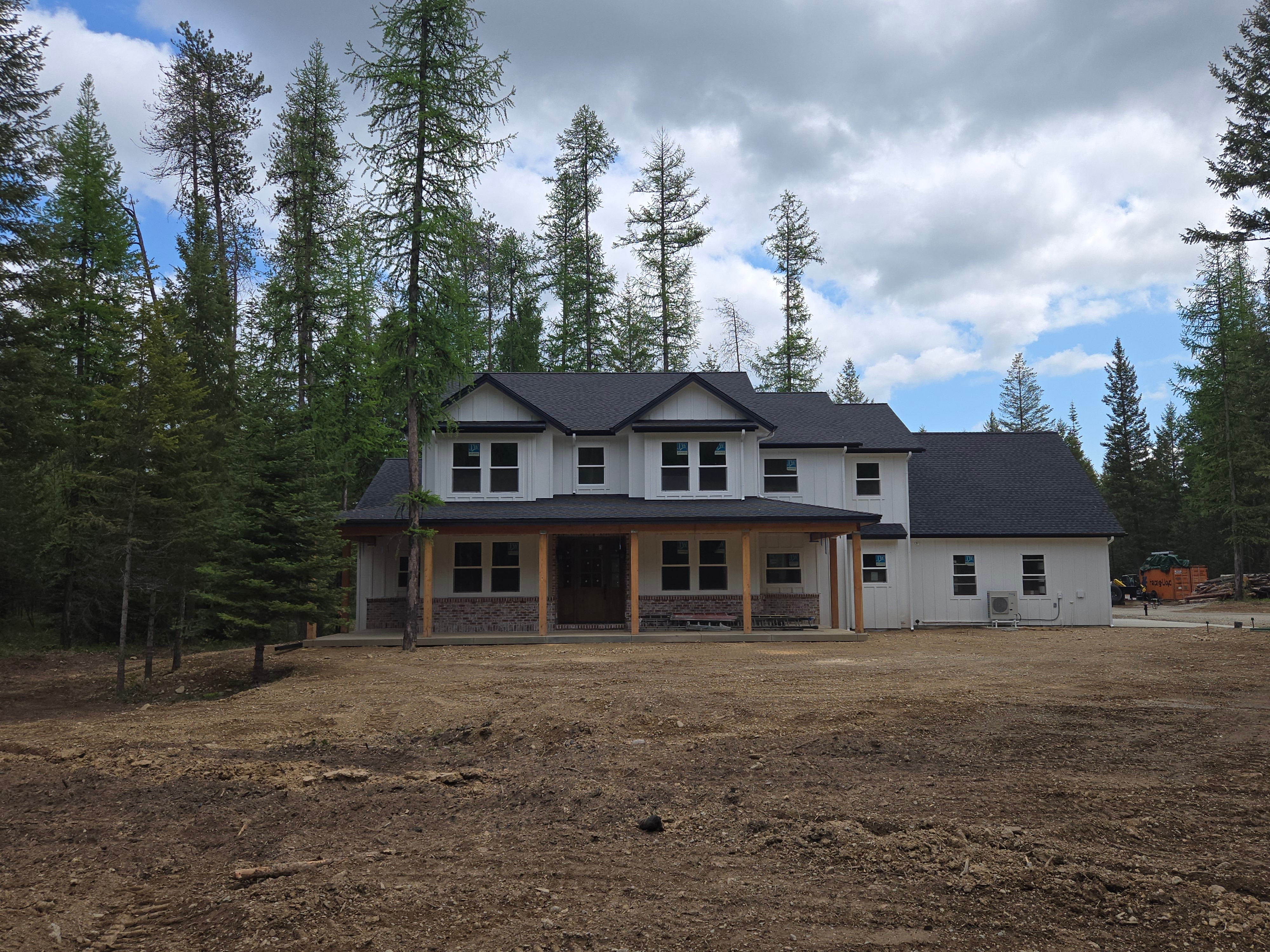 Beautiful custom home exterior with white siding and covered porch, showcasing Brookside's quality craftsmanship